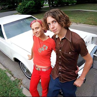Taran Noah Smith and Heidi Van Pelt posing infront of a white car.